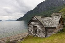 Weathered Wooden House Along Water's Edge — Stock Photo