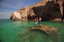 Padre e figlio in piedi sulla roccia nell'oceano — Foto stock