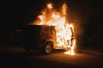 Vehículo en llamas por la noche - foto de stock