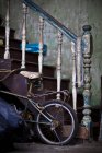 Una vecchia scala con peeling vernice fornisce supporto per la bicicletta di un bambino; George Town Penang Malesia — Foto stock