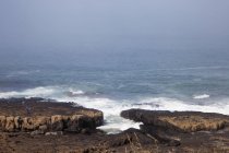 Океан спотыкается о плоскую скалу — стоковое фото