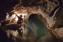 Philippinische Reiseleiterin mit Laterne im Inneren der sommerlichen Höhle oder großen Höhle in der Nähe von Sagada, Luzon, Philippinen — Stockfoto