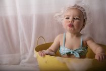 Bebé sentado en una bañera de burbujas - foto de stock