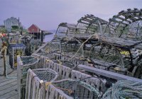 Stacked wooden lobster traps beside sea — Stock Photo