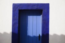 Голубая дверь внутри белой стены — стоковое фото