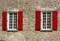 Red shutters on windows of building In lower village of old quebec city. quebec, canada — Stock Photo