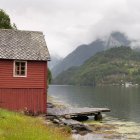 Bâtiment rouge et quai le long du Hardangerfjord — Photo de stock