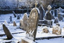 Gruseliger Friedhof im Winter mit Schnee bedeckt — Stockfoto