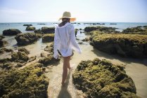 Woman tourist enjoys sunshine on beach of tropical island — Stock Photo