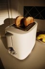 Хлеб тосты в тостере на кухне — стоковое фото