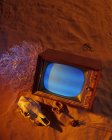 Vieux téléviseur mis sur sable avec crâne — Photo de stock