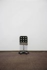 Офисное кресло перед белой стеной с копировальным местом — стоковое фото