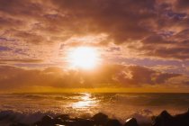 Схід сонця і хвиль, викликаних на скелях — стокове фото