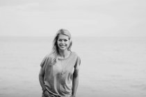 Porträt einer jungen Frau mit langen blonden Haaren am Meer; hastig, sussex, england — Stockfoto