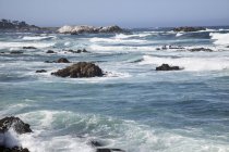 Vagues se brisant près du rivage sur les rochers le long des côtes californiennes — Photo de stock