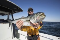 Fischer hält mit Stolz seinen frischen Fang in der Hand. montauk, new york, vereinigte staaten von amerika — Stockfoto