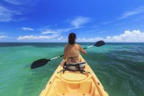 Una mujer en bikini en un kayak en el Caribe, Saint Georges Caye Resort; Belice City, Belice - foto de stock