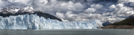 Glaciar en el agua con colinas - foto de stock