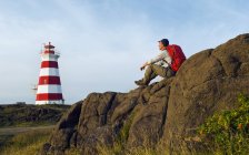 Hiker looking out over lighthouse, bay of fundy, nova scotia, canada — Stock Photo