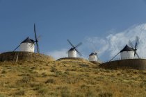 Moulins à vent dans une rangée contre un ciel bleu — Photo de stock