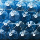 Blue plastic water containers with white lids attached by rope; Seoul, South Korea — Stock Photo
