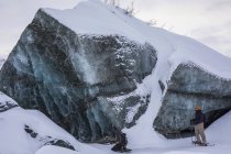 Двое мужчин наблюдают большой кусок льда на леднике Кэнвелл на Аляске, Аляска, США — стоковое фото