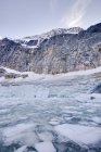 Klippe gegen zugefrorenen See — Stockfoto