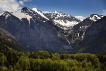 Montañas cubiertas de nieve con una cascada - foto de stock