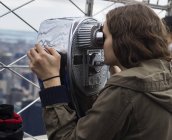 Woman looks through binoculars — Stock Photo