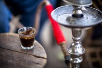 Glass of Turkish coffee on table beside sheesha, closeup — Stock Photo