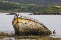 Barco de madeira abandonado afundando na água — Fotografia de Stock