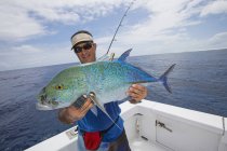 Fisherman holding a fresh caught Jackfish tuna, Tahiti — Stock Photo