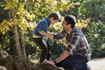 Father and son playing on a large oak tree in a rainforest — Stock Photo