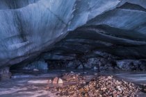 Homem fica dentro de uma caverna de gelo cavernosa no término da geleira Augustana na Cordilheira do Alasca no inverno, Alasca, Estados Unidos da América — Fotografia de Stock