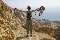 Visão traseira da mulher de pé com os braços estendidos em vista do mar morto. israel — Fotografia de Stock