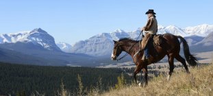 Cowboy riding horseback — Stock Photo