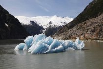 Айсберг в воде с горами — стоковое фото