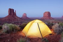 Mittens and tent at dusk — Stock Photo