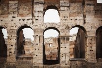 Vecchia parete in pietra del Colosseo con archi — Foto stock