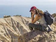 Young woman sitting on rock and looking at camera. ein gedi, dead sea, Israel — Stock Photo