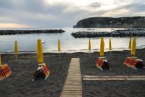 Passerella in legno e ombrelloni gialli — Foto stock