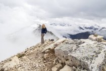 Senderista femenino alcanza cumbre de montaña - foto de stock