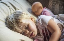 Una niña caucásica con siestas de cabello rubio con su muñeca; Penn Yan, Nueva York, Estados Unidos de América - foto de stock