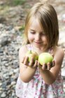 Menina segurando maçãs frescas — Fotografia de Stock
