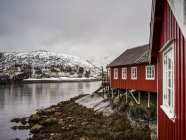 Red building along water's edge — Stock Photo