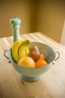 Sieb mit Früchten über dem Tisch — Stockfoto