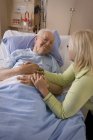 Elderly Man And His Daughter. Woman Sitting By Man In Hospital Bed — Stock Photo