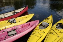 Kayaks coloridos vacíos a la deriva en el agua - foto de stock