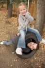 Heureux père et fille sur pneu swing — Photo de stock