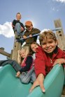 Cinco niños se divierten en el patio de recreo - foto de stock